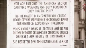 Das berühmte Warnschild am Checkpoint Charlie in Berlin in historischer Optik.
