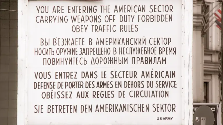 Das berühmte Warnschild am Checkpoint Charlie in Berlin in historischer Optik.