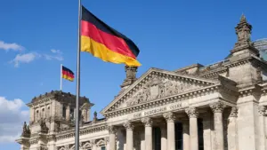Die deutsche Flagge weht stolz vor dem Reichstagsgebäude in Berlin.