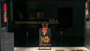 Ein Gemälde auf einer Staffelei in einer dunklen Kunstgalerie präsentiert.
