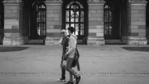 Zwei Männer spazieren gemeinsam durch die historische Innenstadt von München bei Tageslicht.