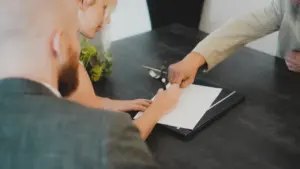 Personen unterschreiben gemeinsam einen offiziellen Arbeitsvertrag an einem Schreibtisch im Büro
