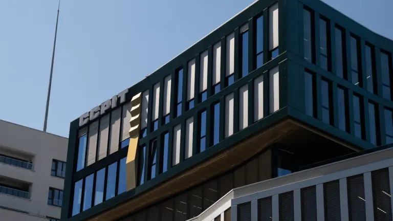 Ein modernes Bürogebäude mit Glasfassade vor einem klaren, hellen Himmel in Deutschland.