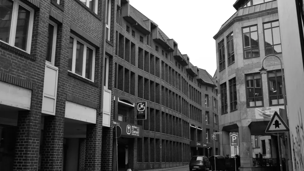 Schwarz-Weiß-Aufnahme einer städtischen Straßenszene, die eine typische norddeutsche Architektur und Atmosphäre vermittelt.