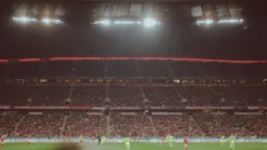 Ein Fußballspiel bei Flutlicht in einem gut gefüllten deutschen Stadion.