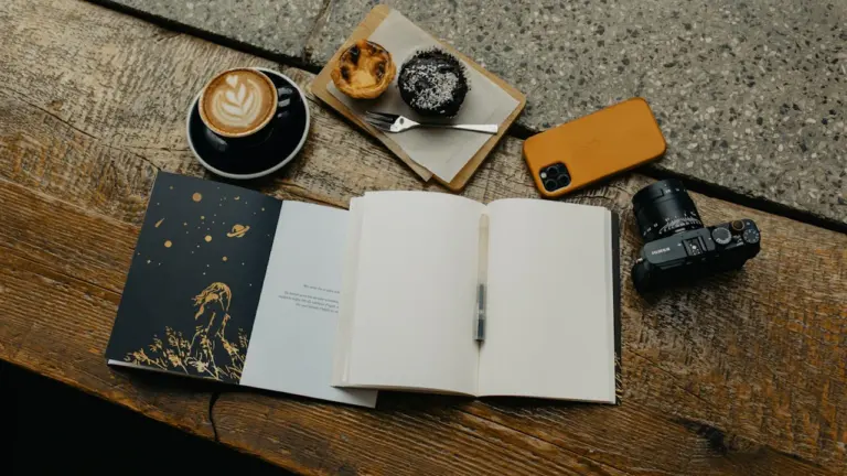 Ein offenes Notizbuch und Kaffee auf einem Holztisch als Symbol für analoge Entschleunigung.