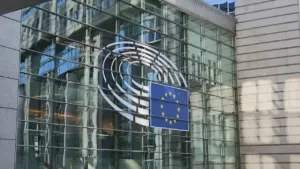 Glasfassade des Europäischen Parlaments mit dem offiziellen EU-Logo im Gebäude.