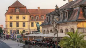Historische Gebäude und eine Statue bei Sonnenuntergang in der Innenstadt von Bad Mergentheim.