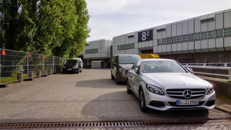 Ein silberner Mercedes vor der Messehalle 8 auf dem Berliner Messegelände.