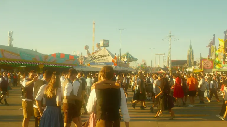 Menschen in traditioneller bayerischer Kleidung besuchen das Oktoberfest auf dem Festgelände in München.