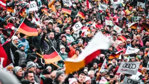 Eine große jubelnde Menschenmenge mit deutschen Flaggen in einem Fußballstadion in München.