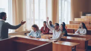 Studenten in einem Hörsaal bei einer aktiven Diskussion während einer Vorlesung.