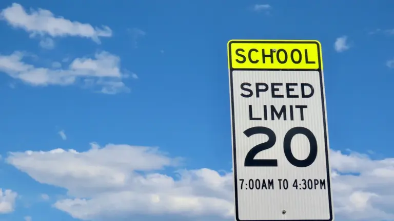 Ein Tempolimit-Schild für eine Schulzone vor einem klaren blauen Himmel.