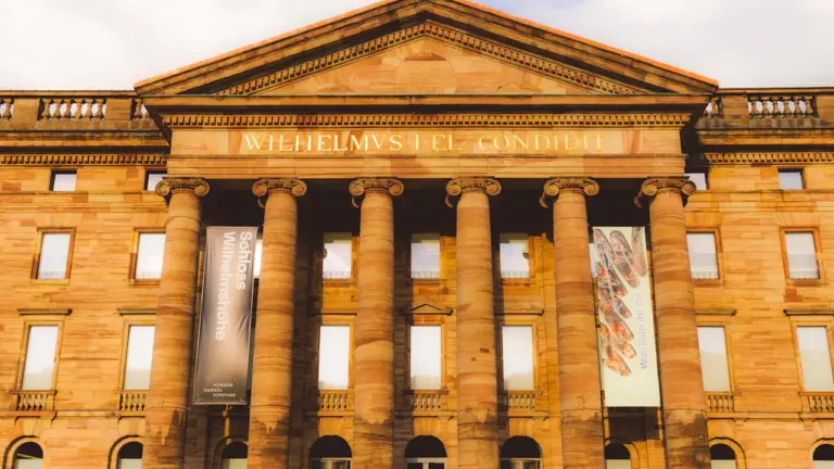 Klassische Architektur mit Säulen und Inschrift vor einem historischen Gebäude in Kassel.