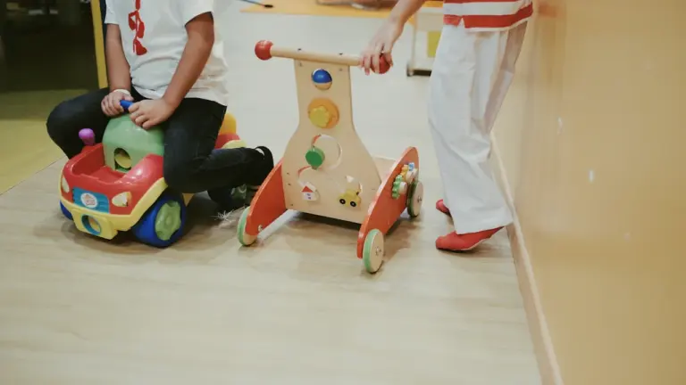 Kinder spielen gemeinsam mit bunten Holzspielzeugen in einer Betreuungseinrichtung.