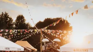 Festliche Stimmung mit Wimpelketten und Bierzelten auf einem deutschen Volksfest bei Sonnenuntergang.