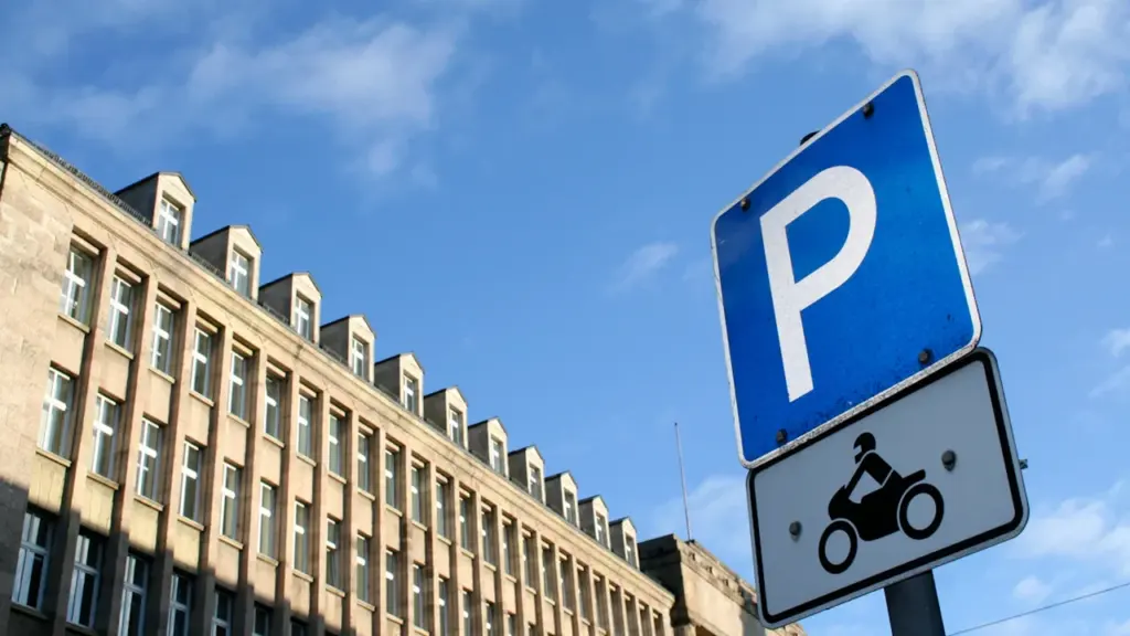 Ein blaues Parkschild vor einem typischen deutschen Verwaltungsgebäude unter blauem Himmel in Hamburg.