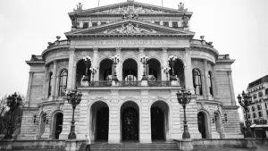 Die Alte Oper Frankfurt in schwarz-weiß bei Tageslicht von vorne betrachtet.