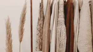 Warme Herbstkleidung und Strickmode auf einem Kleiderständer ordentlich sortiert für die Saison.