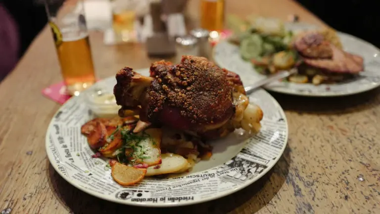 Deftiges deutsches Abendessen mit Eisbein und Bier in einem gemütlichen Restaurant in Deutschland.