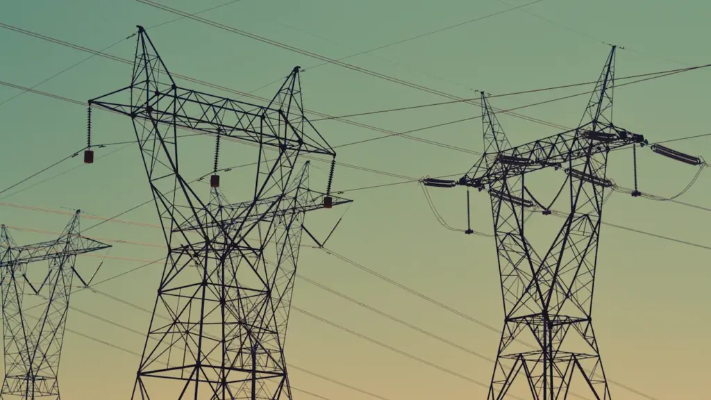 Strommasten vor einem bewölkten Himmel symbolisieren die Energieversorgung und den Strommarkt.