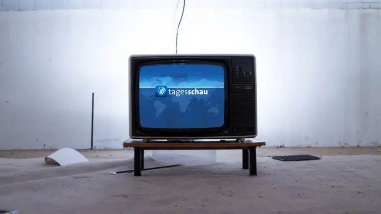Ein alter Röhrenfernseher zeigt das Logo der deutschen Nachrichtensendung Tagesschau.